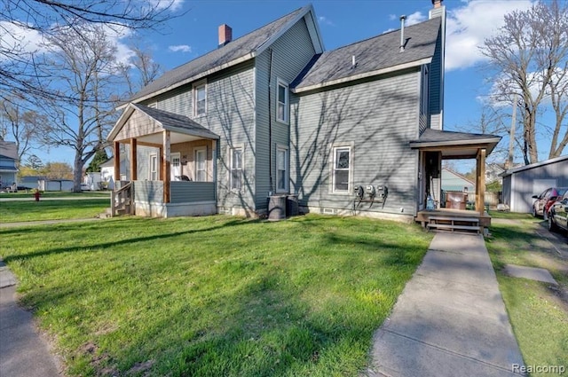 back of house featuring covered porch, a yard, and central air condition unit