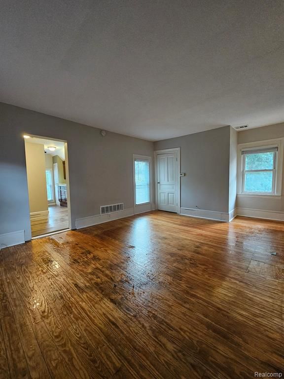 unfurnished room featuring a textured ceiling and light hardwood / wood-style flooring