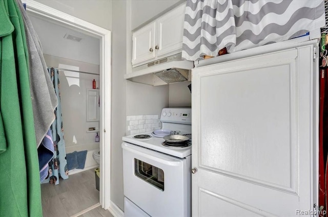 kitchen featuring white cabinets, wood-type flooring, and white electric range