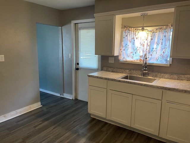 1981 Ray St, Muskegon, MI 49442 - kitchen featuring a sink, dark wood finished floors, light countertops, white cabinets, and baseboards
