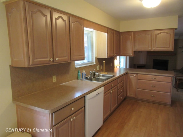 kitchen with sink, a brick fireplace, light hardwood / wood-style flooring, backsplash, and white dishwasher