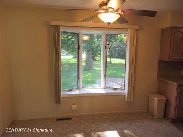 unfurnished dining area featuring carpet, ceiling fan, and a wealth of natural light