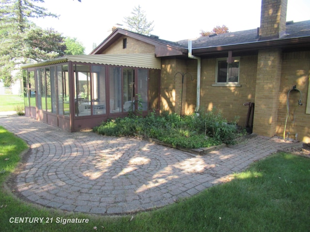 back of house with a patio area and a sunroom