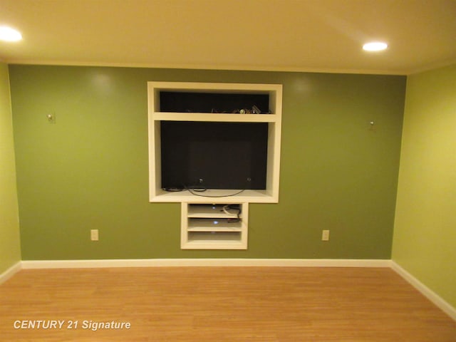 unfurnished living room featuring hardwood / wood-style flooring and built in features