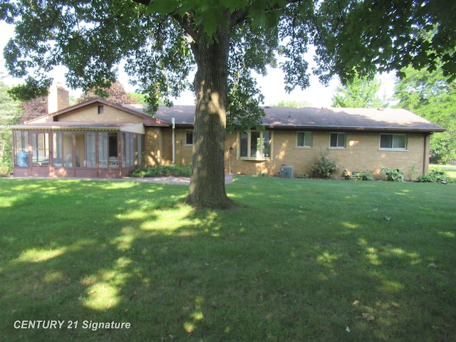 ranch-style home with a front yard and a sunroom