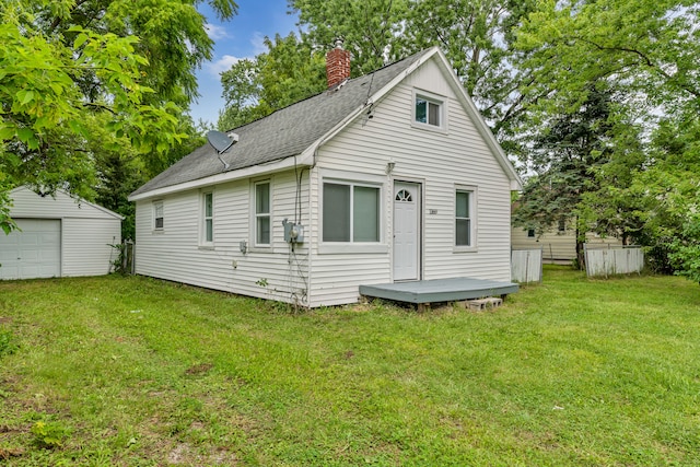 view of front of house with a garage, a front lawn, and an outdoor structure