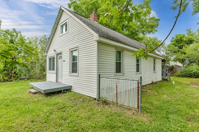 view of home's exterior with a deck and a lawn