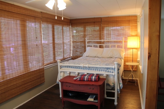 bedroom featuring dark hardwood / wood-style floors, ceiling fan, and ornamental molding