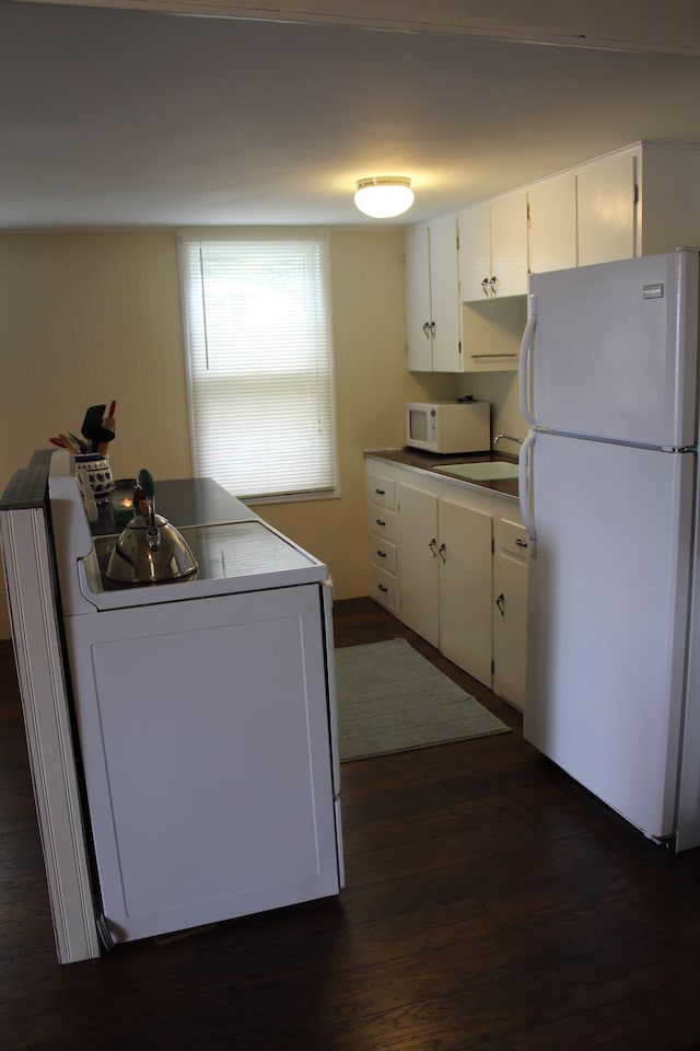 kitchen featuring dark hardwood / wood-style flooring, white cabinets, white appliances, and sink