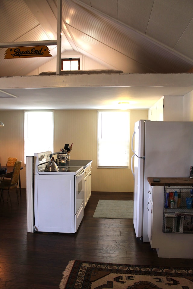 kitchen featuring vaulted ceiling with beams, a wealth of natural light, dark hardwood / wood-style flooring, and white appliances