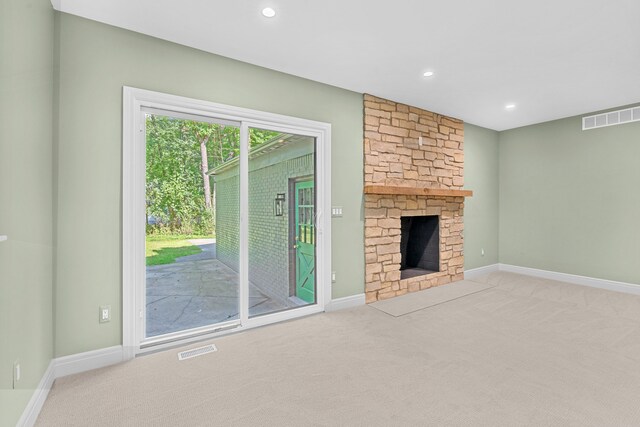 unfurnished living room featuring light carpet and a fireplace