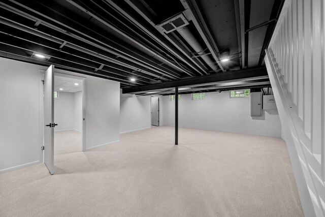 basement with electric panel and light colored carpet