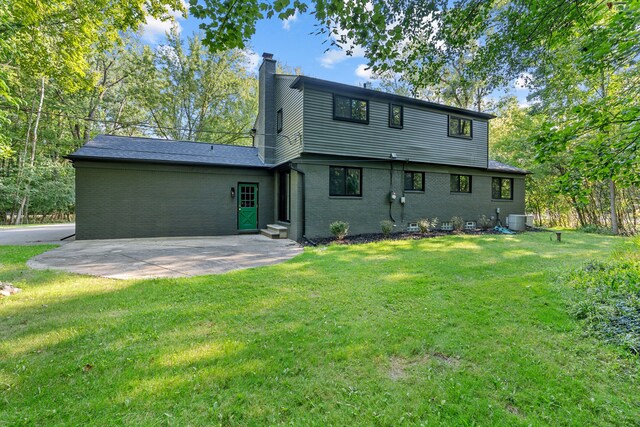 rear view of house with a patio area, a yard, and central AC unit