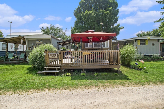 rear view of property with a deck and a yard