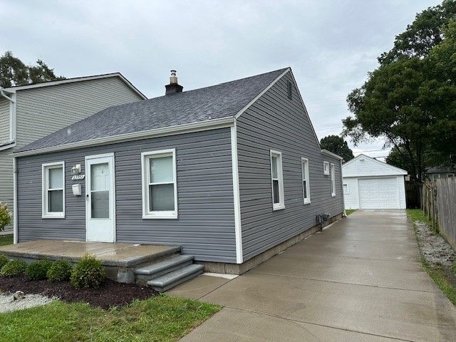 view of front of house with a garage and an outdoor structure