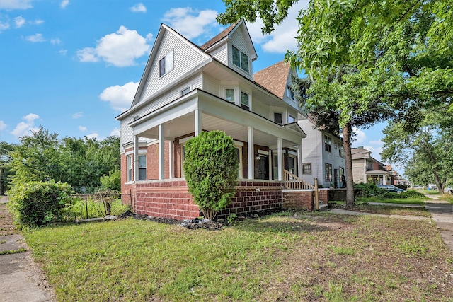 view of side of property with a lawn and a porch