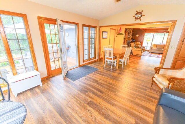 1130 W Higgins Lake Dr, Roscommon, MI 48653 - dining room featuring vaulted ceiling, wood finished floors, plenty of natural light, and baseboards