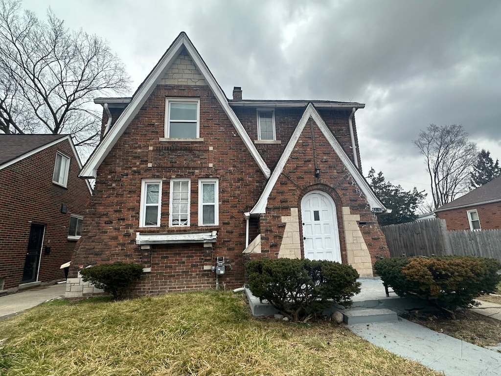 tudor-style house featuring a front lawn