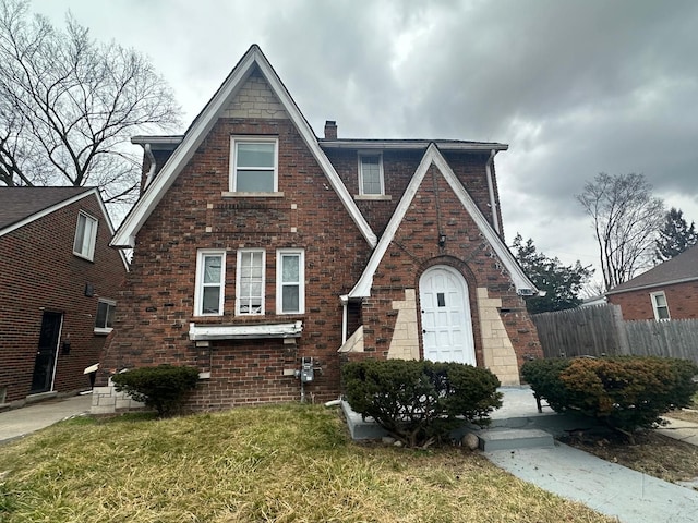 tudor-style house featuring a front lawn