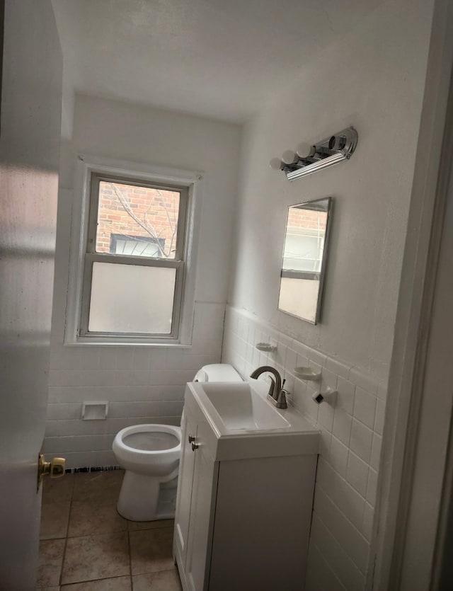 bathroom featuring tile patterned flooring, vanity, toilet, and tile walls