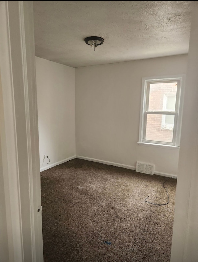 unfurnished room with carpet floors and a textured ceiling