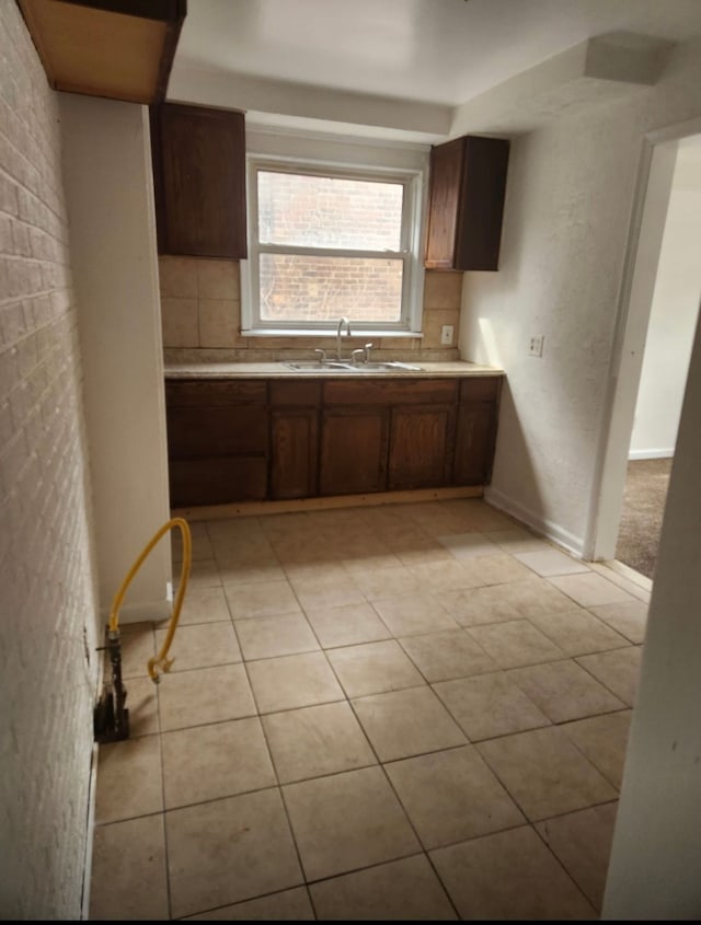 kitchen featuring backsplash, sink, and light tile patterned floors