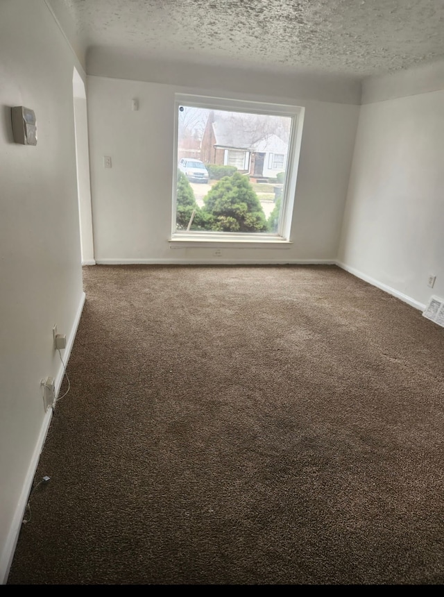 carpeted spare room with a textured ceiling