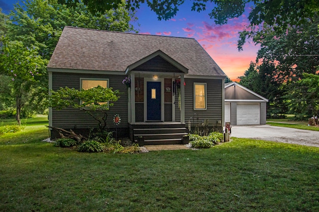 bungalow-style house featuring a garage and a yard