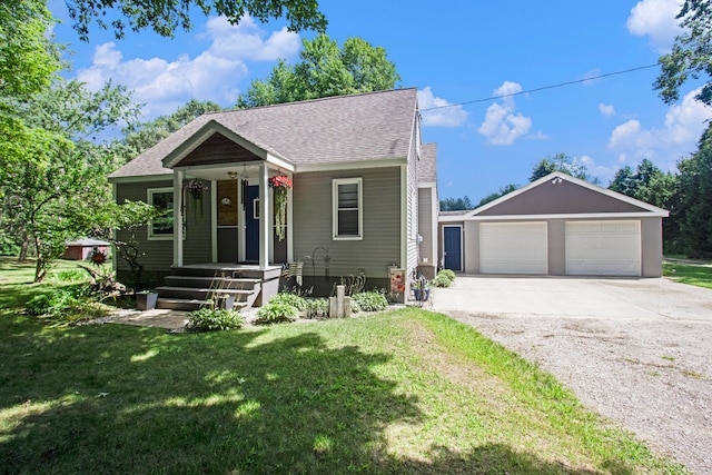 view of front of house featuring an outdoor structure, a front yard, a porch, and a garage