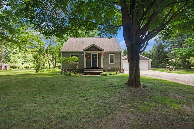 bungalow with a garage, an outbuilding, and a front yard