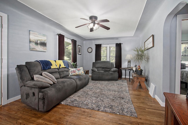 living room with dark hardwood / wood-style floors and ceiling fan