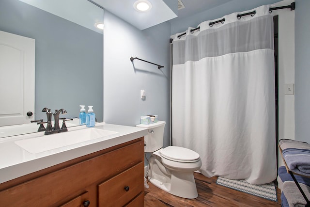 bathroom featuring vanity, wood-type flooring, and toilet