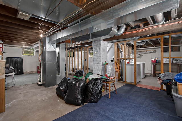 basement with heating unit and washer and clothes dryer