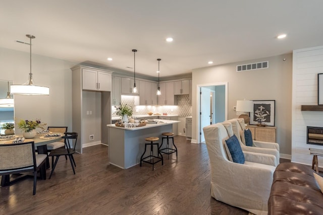 637 Woodland Dr, Dexter, MI 48130 - kitchen featuring open floor plan, tasteful backsplash, a breakfast bar, a kitchen island, and recessed lighting