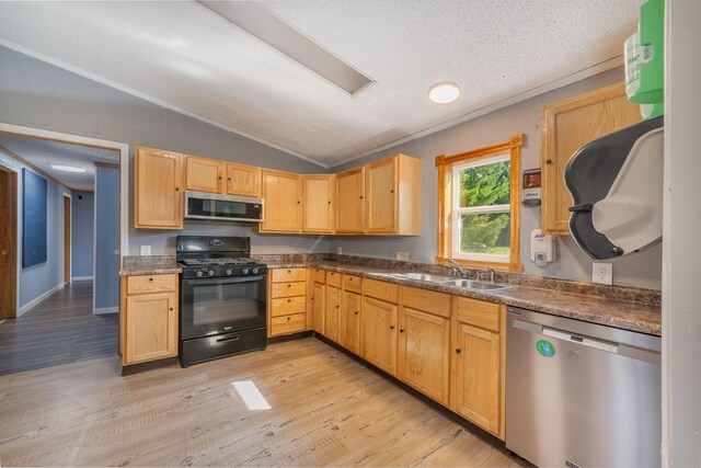 9284 M-35, Gladstone, MI 49837 - kitchen featuring stainless steel appliances, a sink, vaulted ceiling, light brown cabinetry, and a textured ceiling
