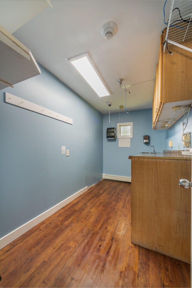 9284 M-35, Gladstone, MI 49837 - kitchen featuring dark wood-type flooring, brown cabinets, baseboards, and a sink