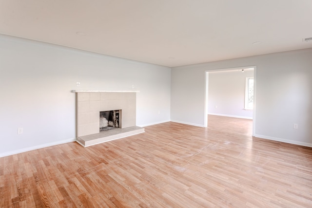 unfurnished living room featuring light hardwood / wood-style flooring and a fireplace