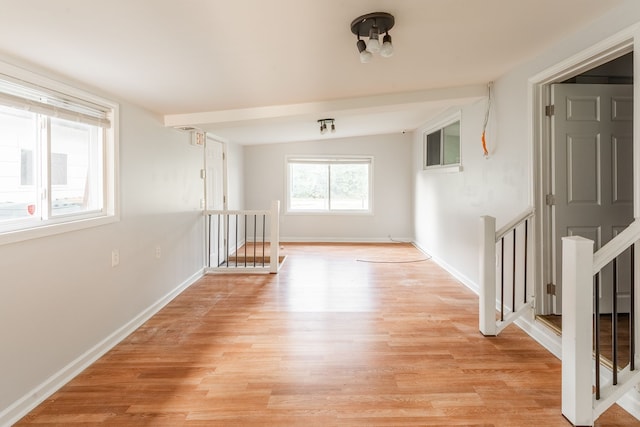 unfurnished room featuring vaulted ceiling and light hardwood / wood-style flooring