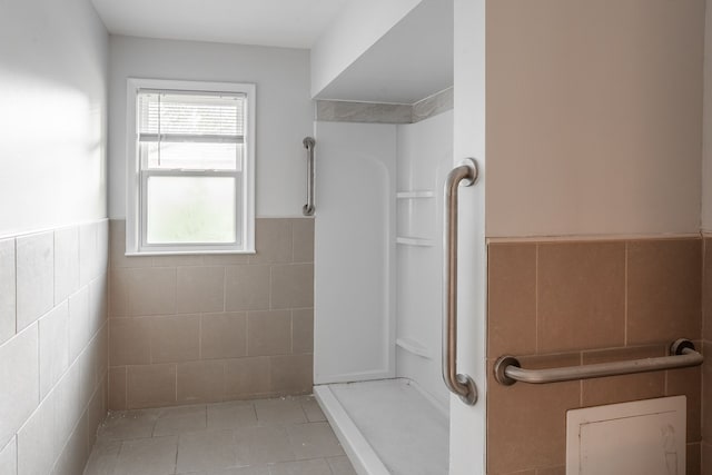 bathroom featuring tile walls, walk in shower, a wealth of natural light, and tile patterned floors