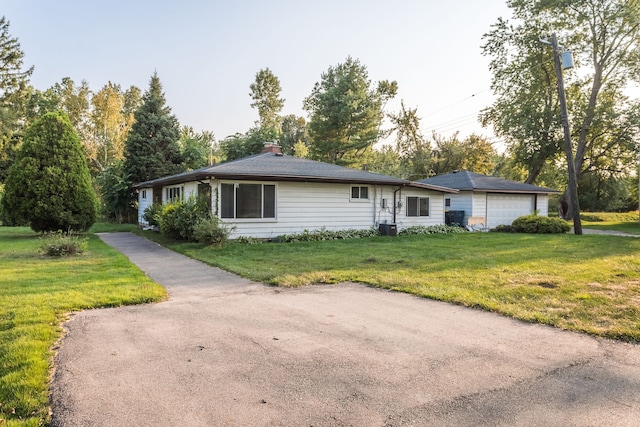 ranch-style house featuring a front lawn and a garage