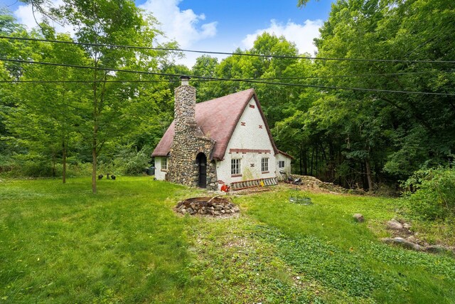 43550 Reservoir St, Plymouth, MI 48170 - view of side of home with a chimney, a yard, and a forest view