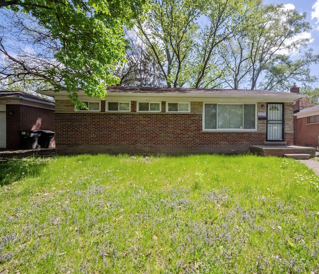 view of front of property with brick siding and a front lawn