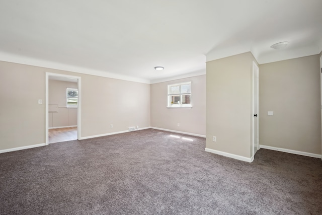 spare room featuring carpet and baseboards
