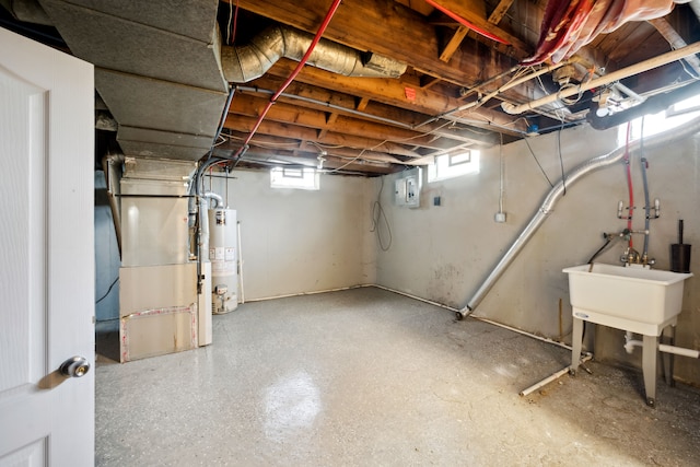 below grade area with gas water heater, heating unit, and electric panel
