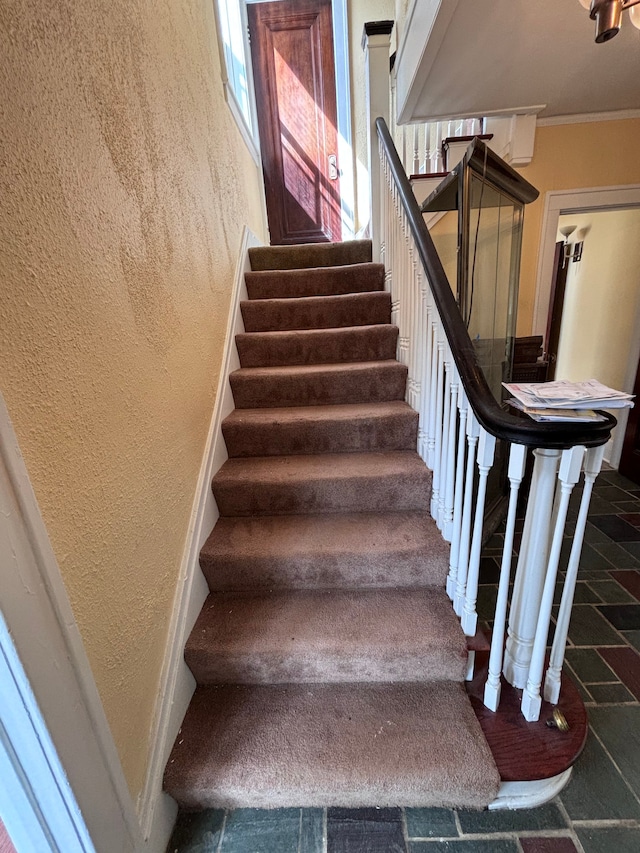 staircase featuring ornamental molding