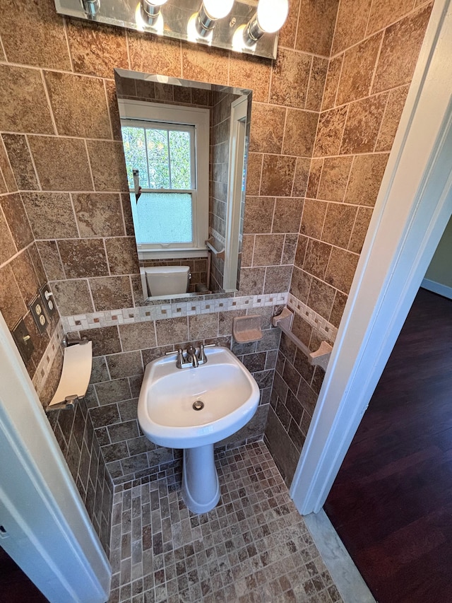 bathroom with tasteful backsplash, sink, tile walls, and toilet