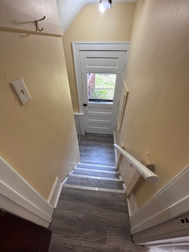 stairs featuring hardwood / wood-style flooring and lofted ceiling