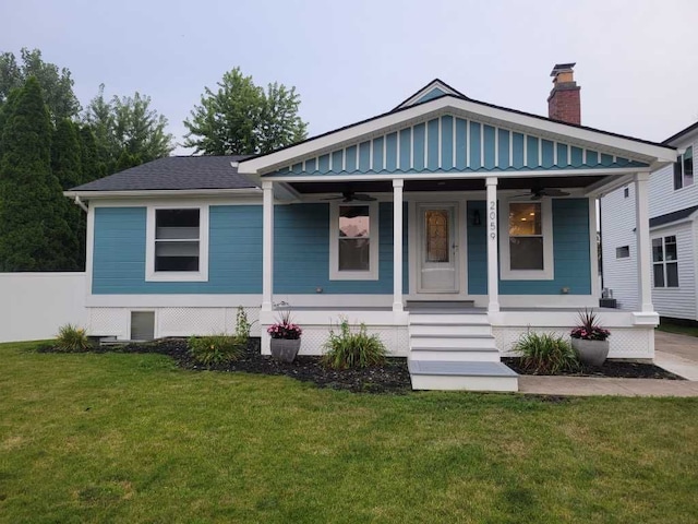 bungalow-style house featuring ceiling fan, a porch, and a front lawn