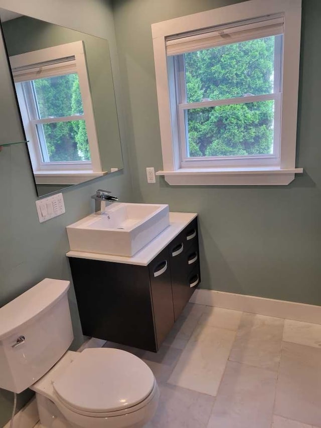 bathroom with vanity, toilet, and plenty of natural light