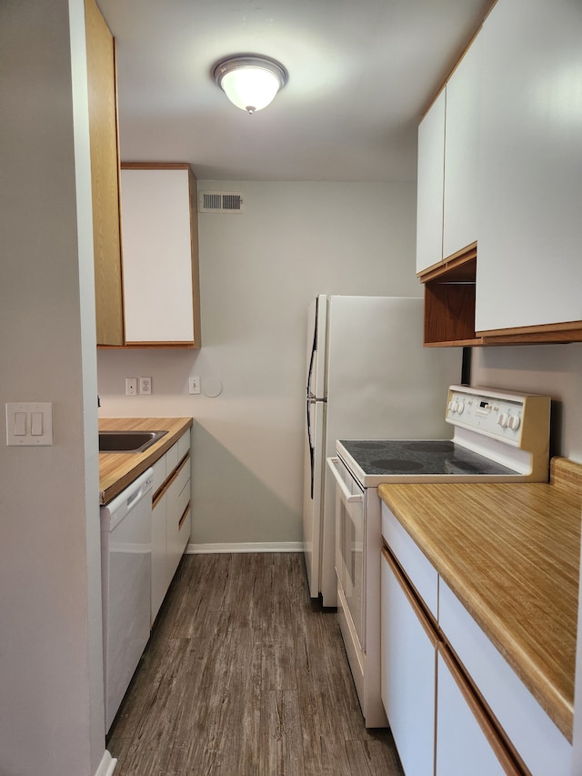 kitchen with white appliances, white cabinetry, dark wood-type flooring, and sink